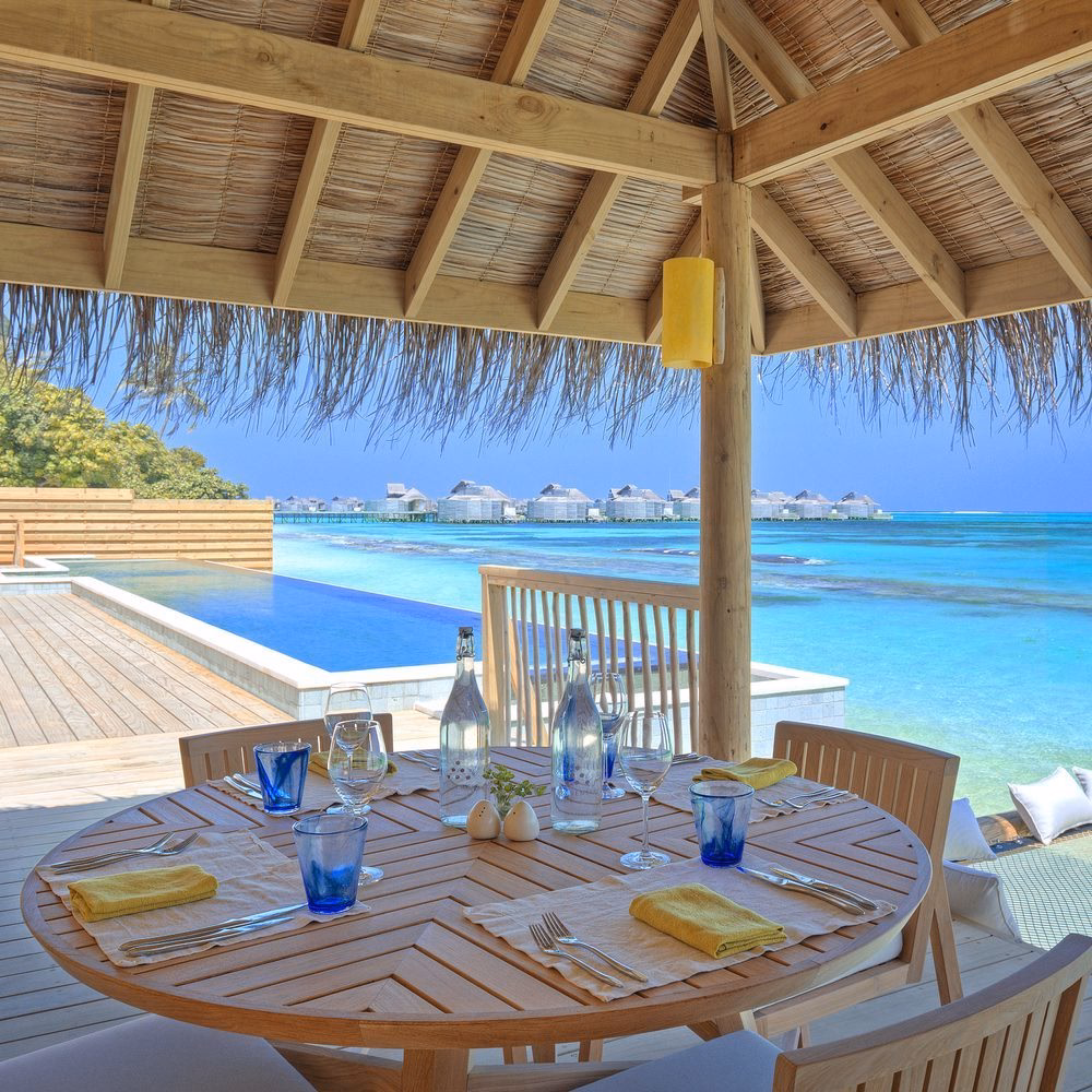 Outdoor dining area with sea view at Six Senses Laamu