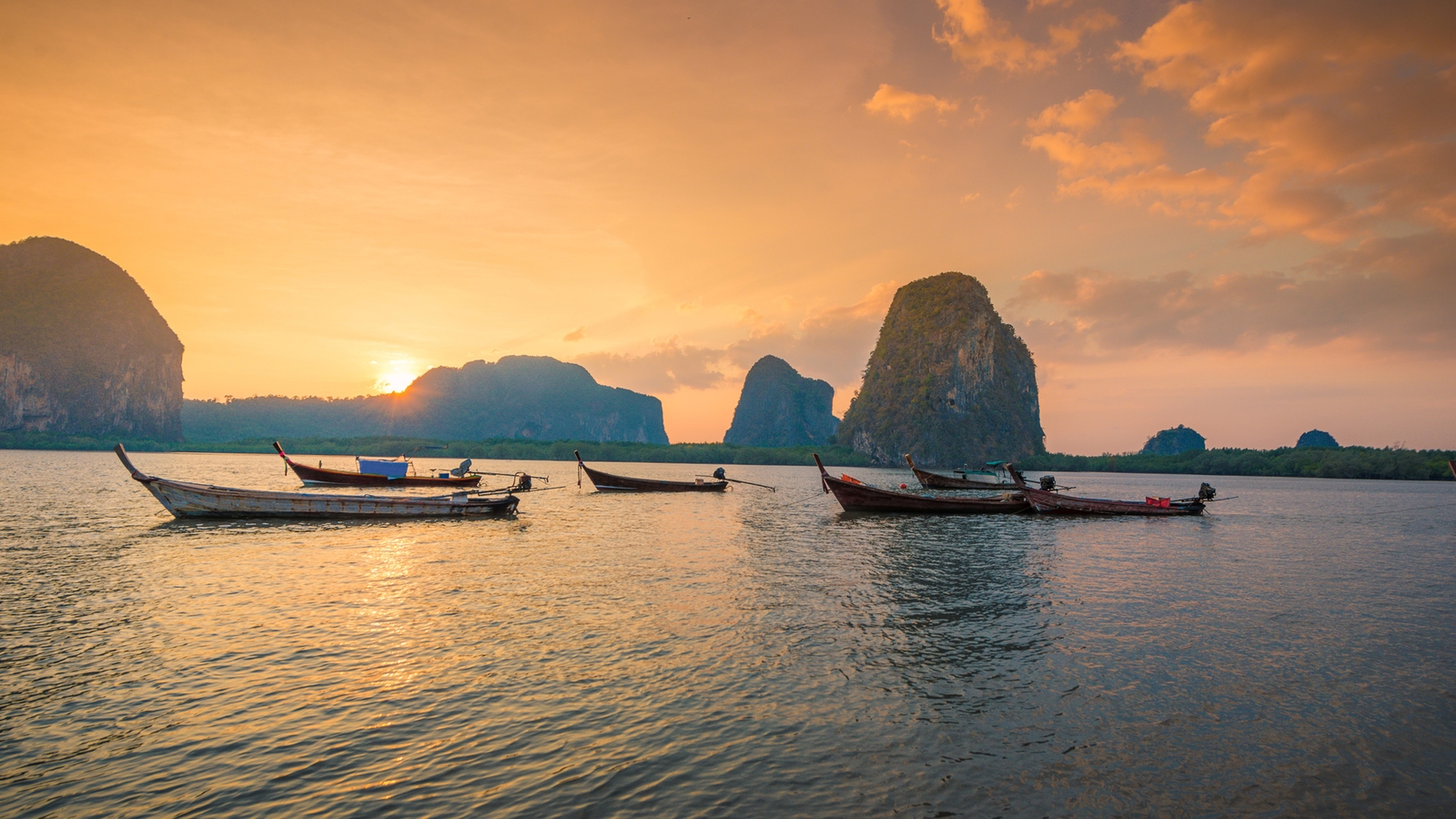 Luxury Thailand Tours - Sunset over Krabi in Thailand as boats sail past
