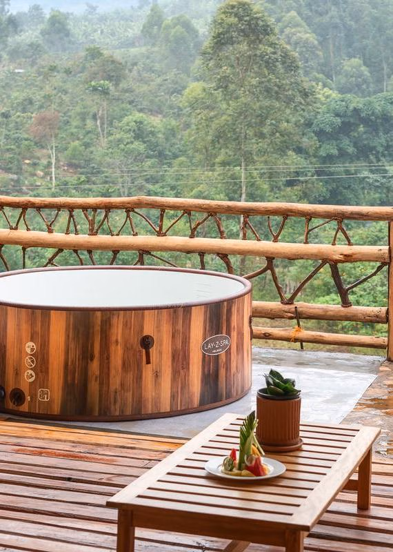 Lay-Z-Spa hot tub and a fruit platter on a wooden deck overlooking a forest at Mahogany Springs uganda.