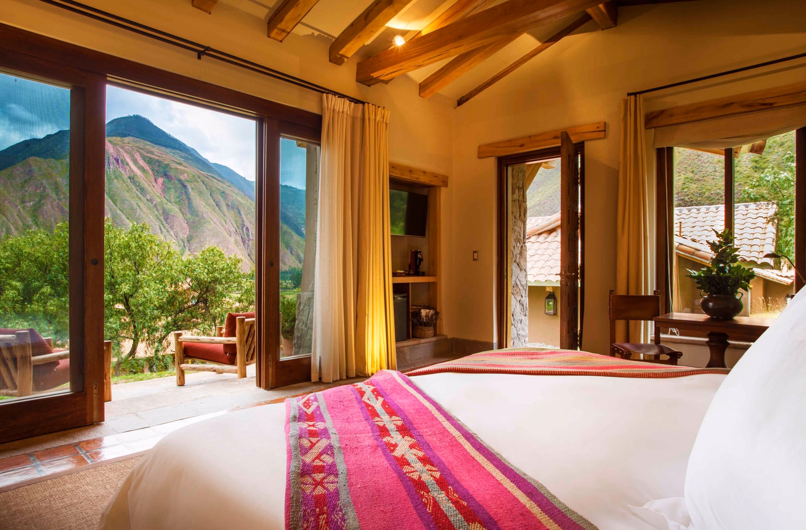 Rustic bedroom with large windows offering a scenic mountain view.