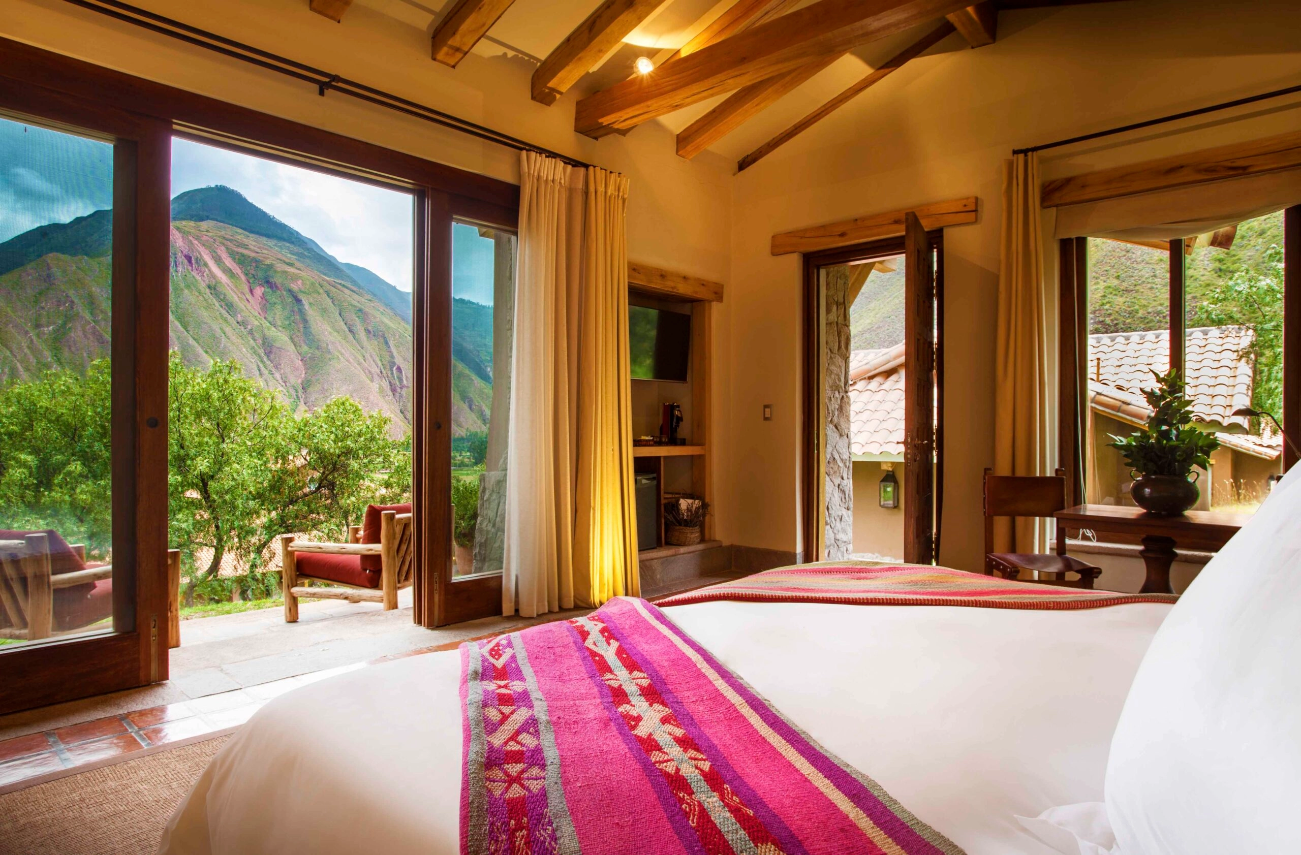 Rustic bedroom with large windows offering a scenic mountain view.