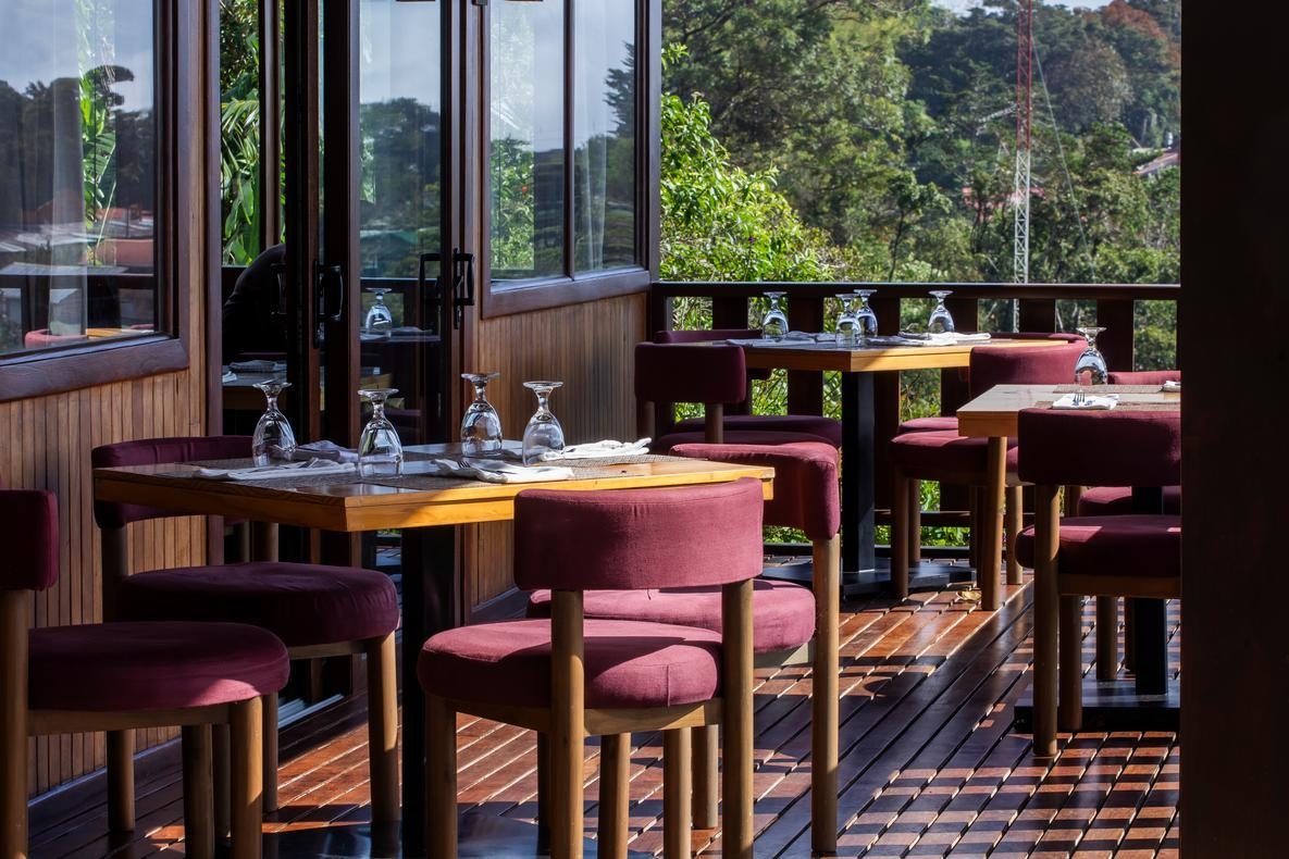 A close-up of chairs and tables in the al fresco area of Senda Monteverde Hotel's restaurant
