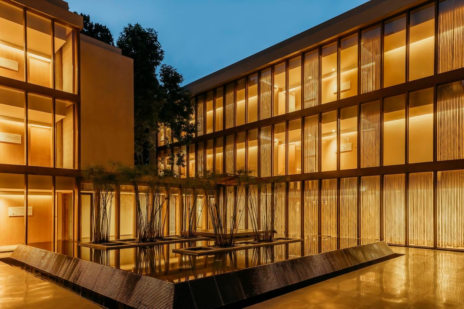 The reflection pond lit up at night at Six Senses Vana in India