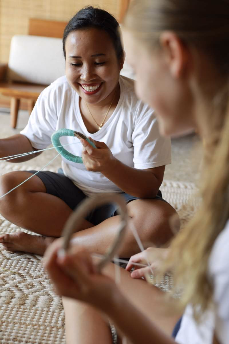 A woman and a child sitting on the floor doing crafts together.