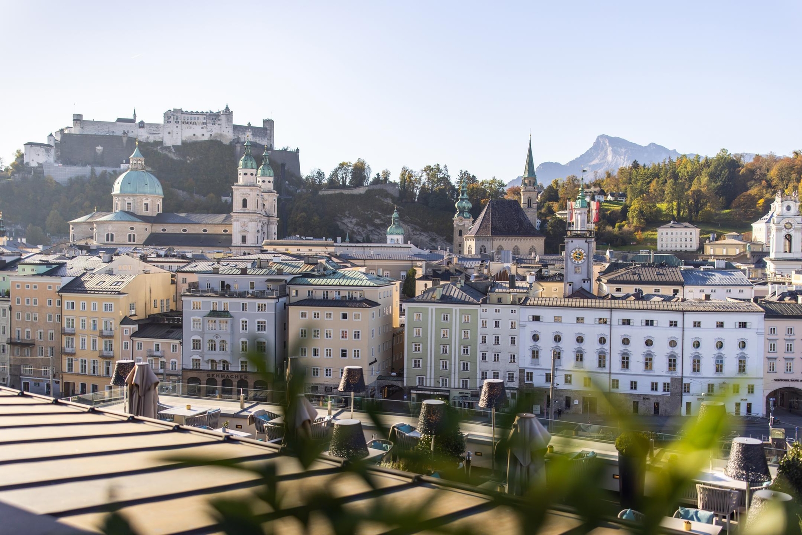 View of Salzburg cityscape with historic buildings and Hohensalzburg Fortress on the hill.