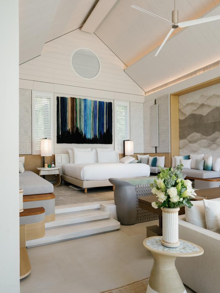 The bedroom of a beach villa at Cheval Blanc Seychelles, featuring a neutral palette and airy, vaulted ceilings.