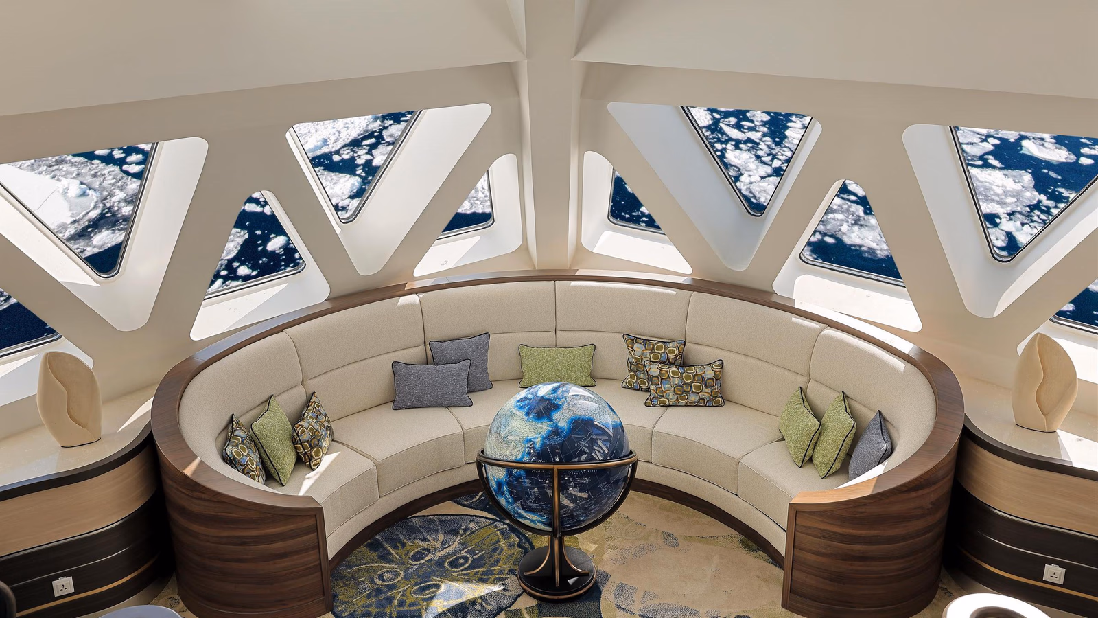 A curved sofa and globe sit beneath triangular windows viewing sea ice on the Douglas Mawson.