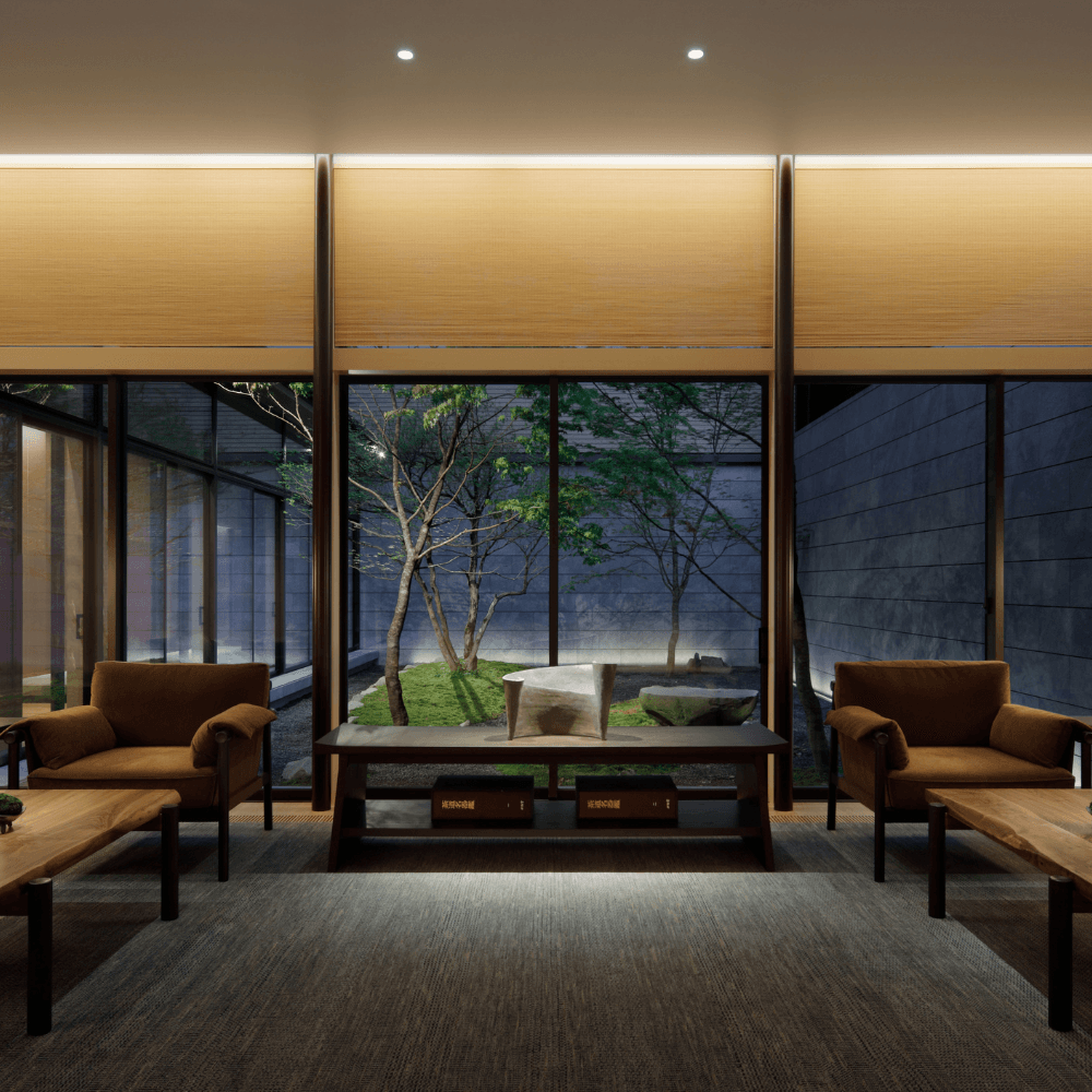 Modern hotel lobby at night with large windows with view of small courtyard