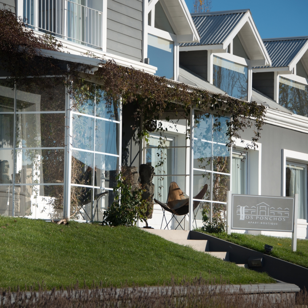 Exterior view of the lodge's big windows and gabled roofs with a small lawn at the front.