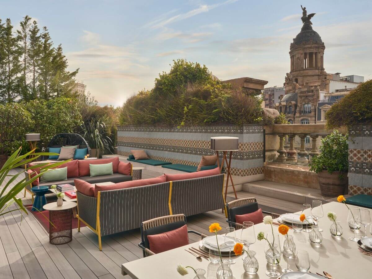 A rooftop terrace with colourful furniture next to an ornate domed building