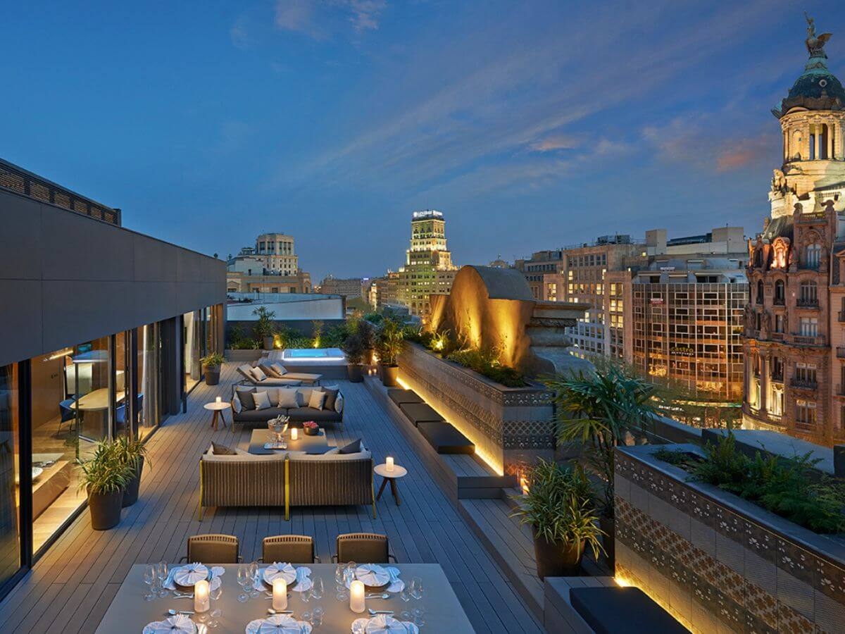 A candlelit rooftop terrace in the evening with views of Barcelona