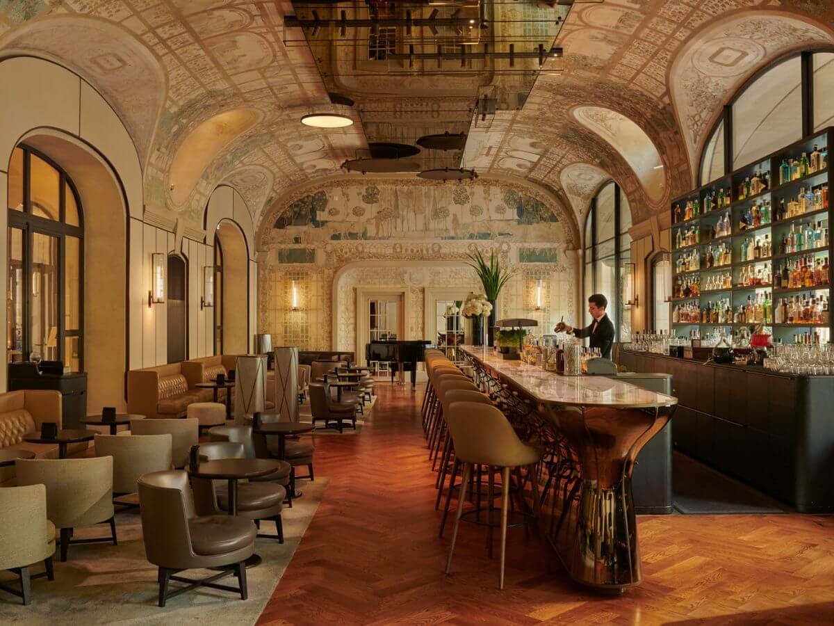 An elegant hotel bar with a curved and frescoed ceiling