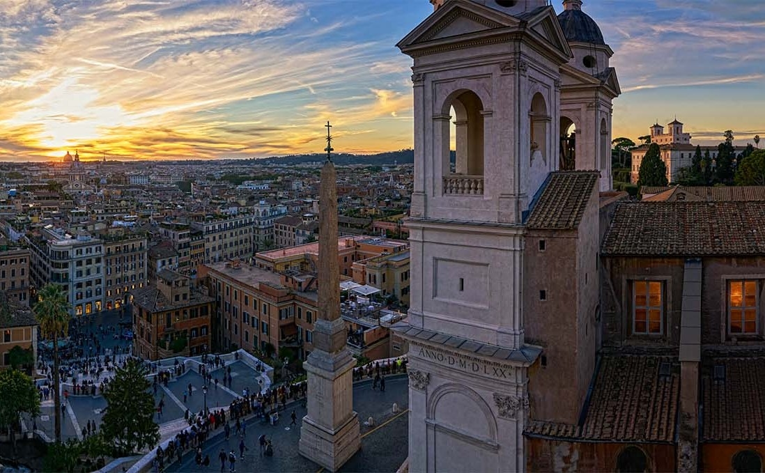 A view of Rome's monuments and rooftops, with the turrets of the Church of Trinità dei Monti in the foreground.