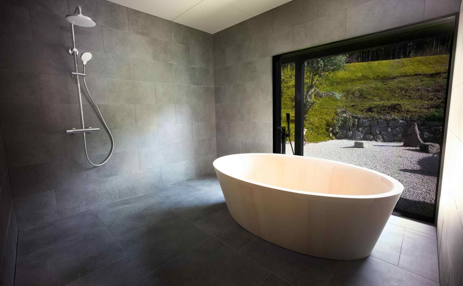 One of the bathrooms at Zenagi, with a large wooden bathtub and window onto a Zen garden