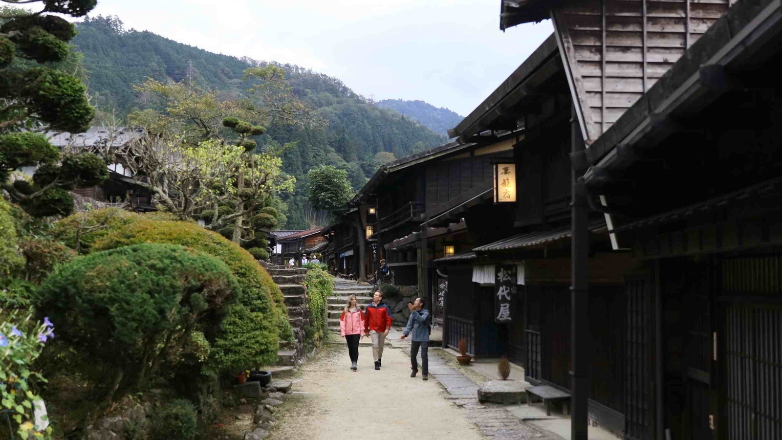People walking through a traditional Japanese post town along a section of the Nakasendo trail