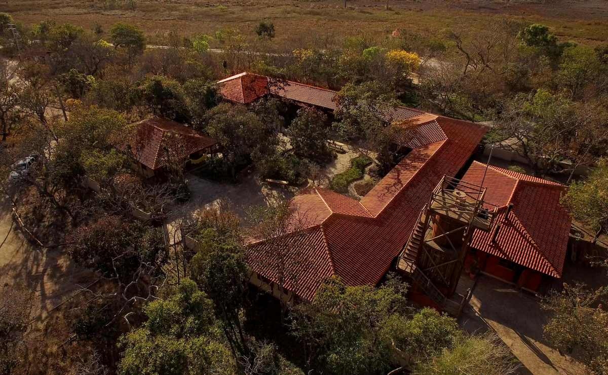 Red-tiled roofs set in a U-shape and surrounded by the savannah.