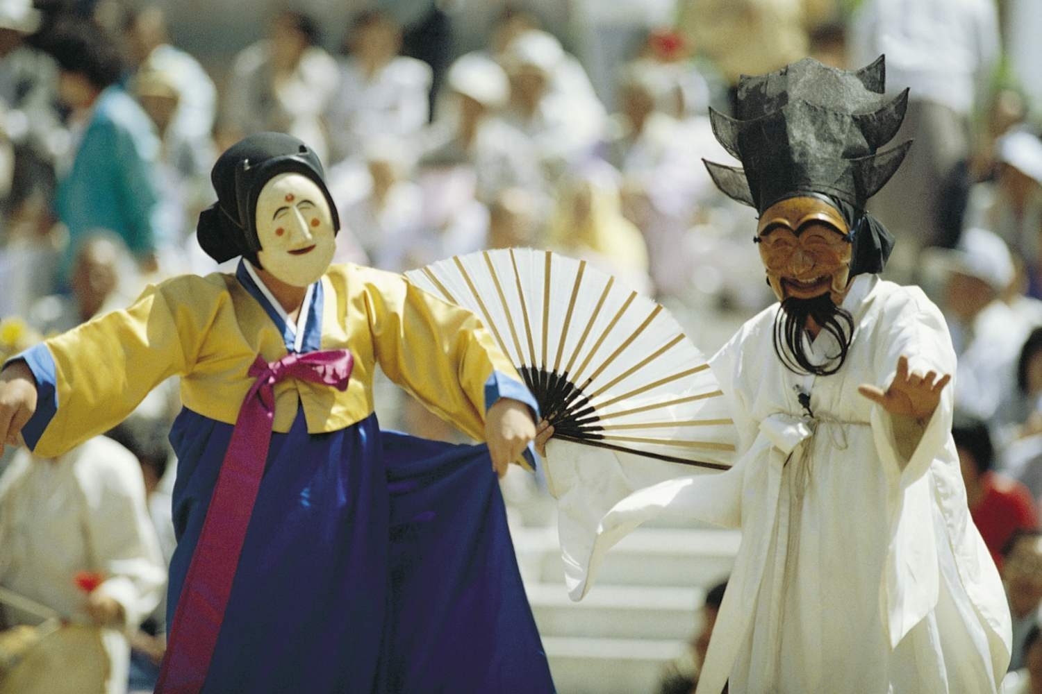 Performers in traditional Korean hanok costumes and distinctive Hahoe masks dancing at Rakkojae Andong.