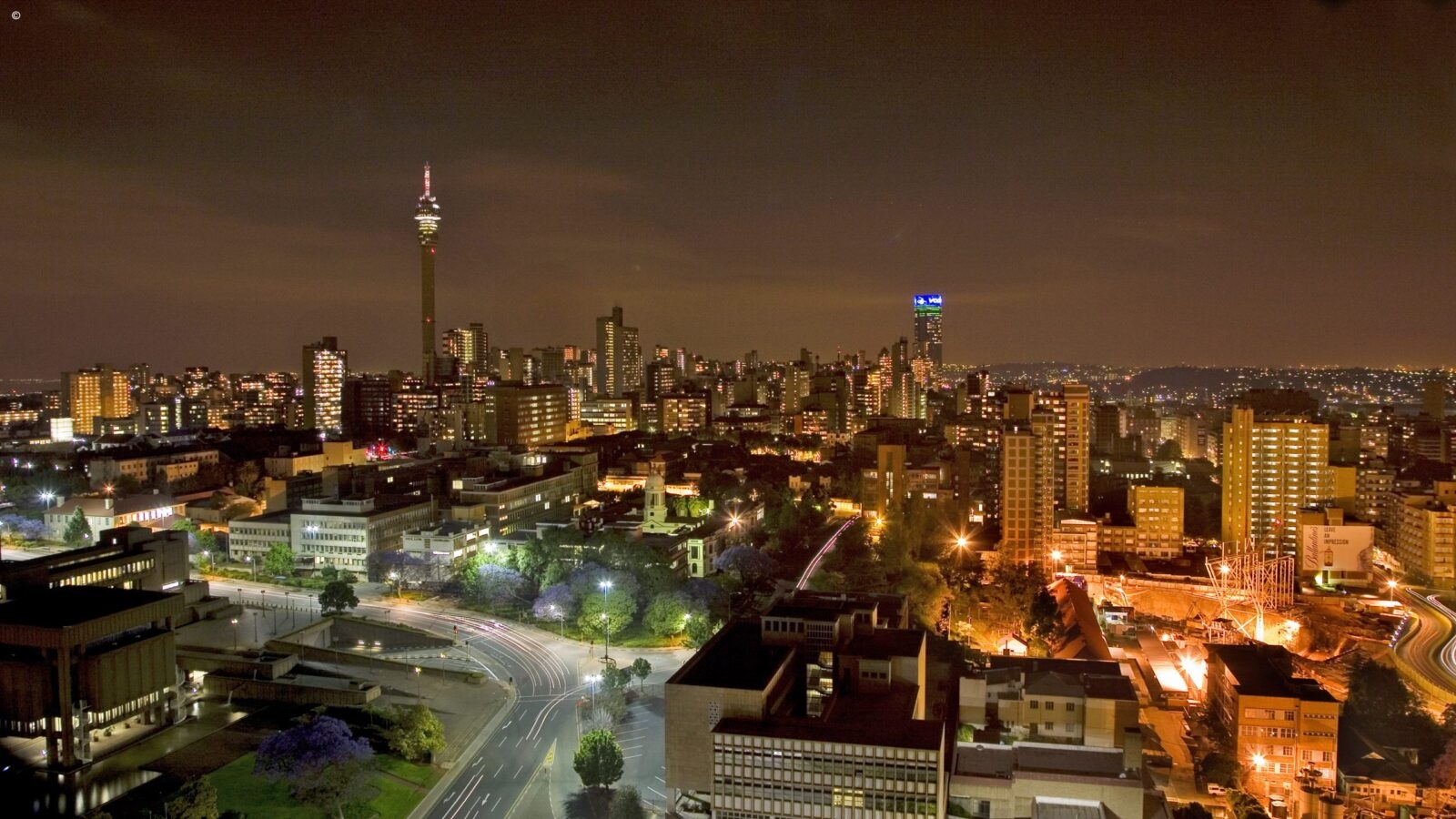 Nighttime city lights and the illuminated Hillbrow Tower on luxury Johannesburg vacations.