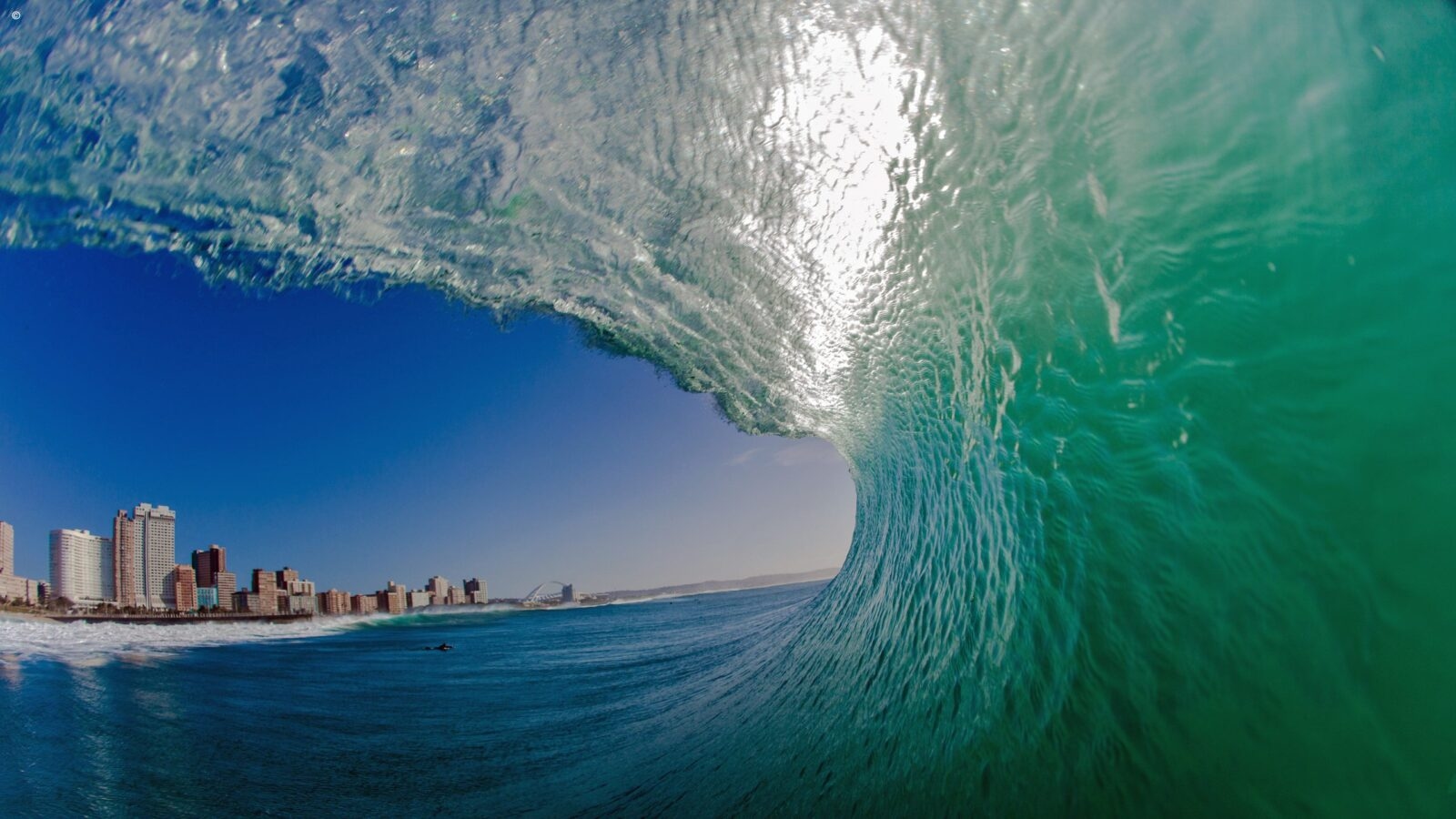 iew from inside a crashing wave looking at the city buildings during luxury Durban trips.