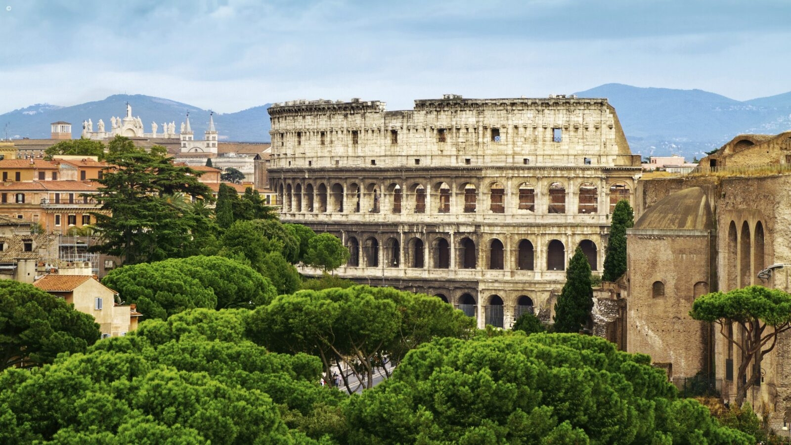 Luxury Italy Tours - Rome Colosseum amongst lush green trees