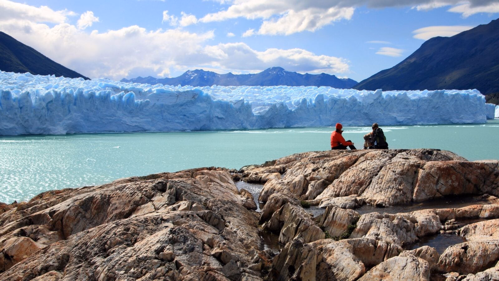Travelers overlooking the massive Perito Moreno Glacier on luxury Latin America honeymoon trips.
