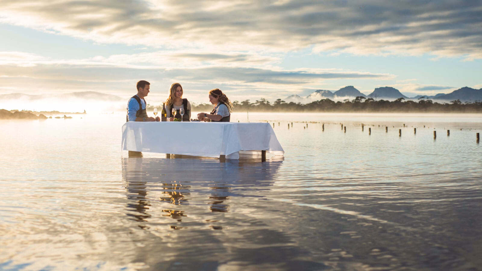 People sitting at a table on a sandy beach