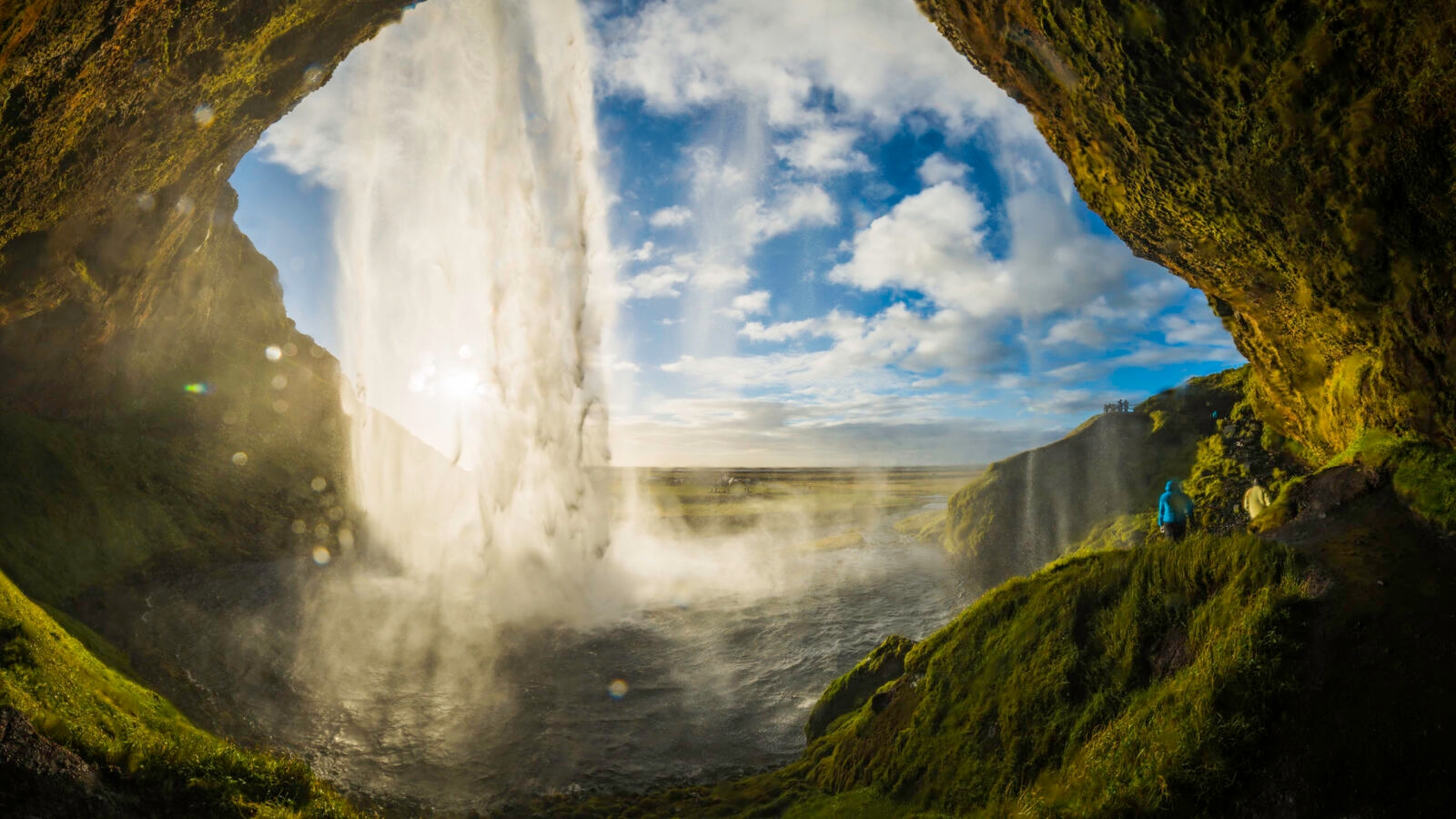 Waterfall tumbling into river above cavern mouth Seljalandsfoss Iceland