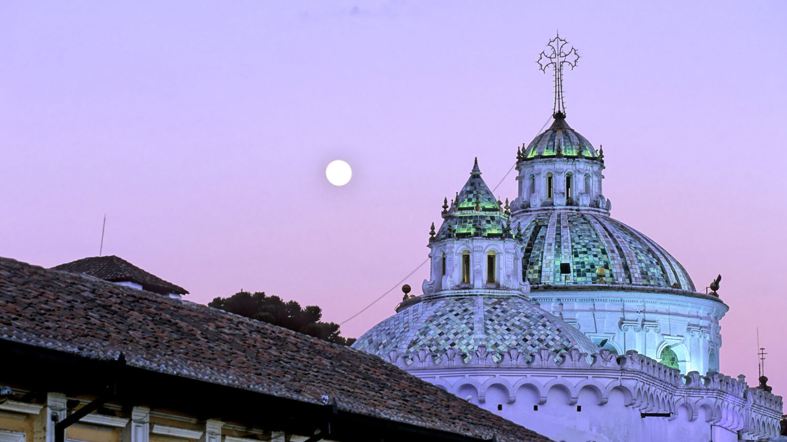 Full moon casting soft light on the Basilica del Voto Nacinoal in Quito, Ecuador at twilight