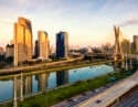 The skyline of Sao Paulo with the tops of its tall buildings bathed in bright sunlight.