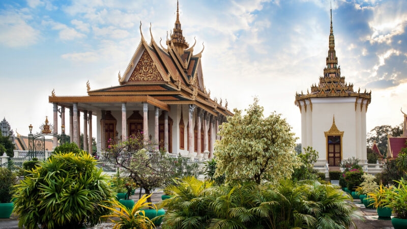 Ornate traditional Cambodian temple buildings with gold spires and manicured gardens at the Royal Palace.