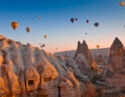 Hot Air Balloons rise up over the Goreme Valley in Cappadocia, Turkey