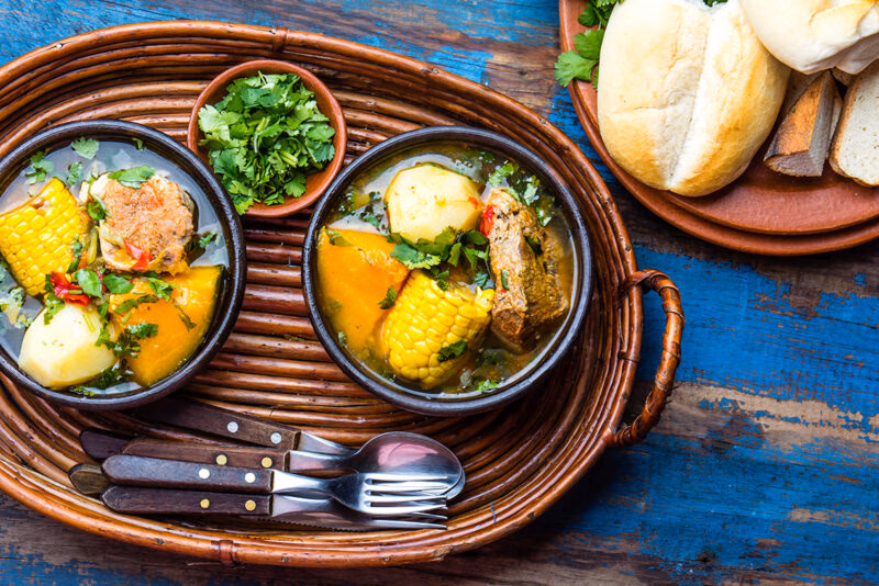 Two bowls of hearty vegetable and meat stew with bread, featured on luxury Chile tours.