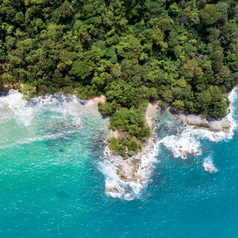 Luxury Thailand Tours - Tropical Sea Aerial view drone shot of amazing beautiful nature background and clear water with wave crashing on rocks coast in phuket Thailand.