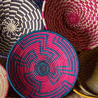 A close-up view of a selection of brightly colored, intricately handwoven Rwandan baskets. Perfect for your luxury Rwanda holidays.