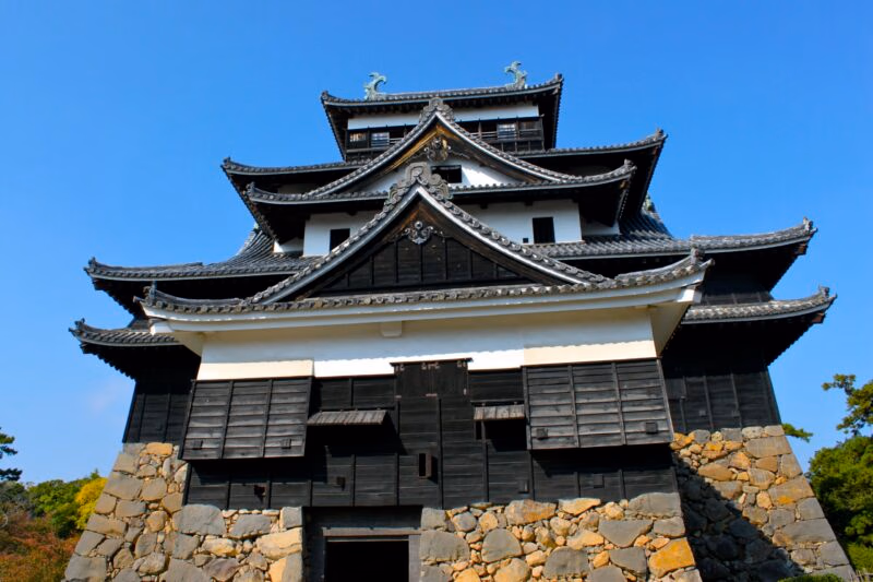 Private Japan Luxury Tours - a large dark coloured temple against a blue sky