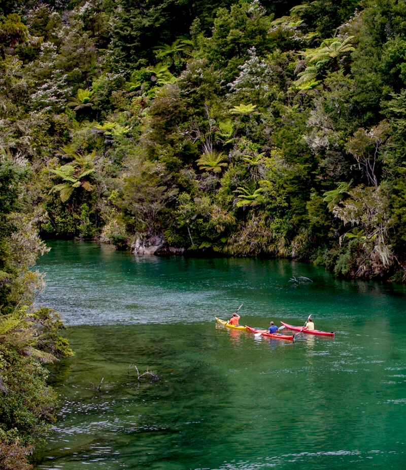 Jacada New Zealand - People in a kayak on a still blue river