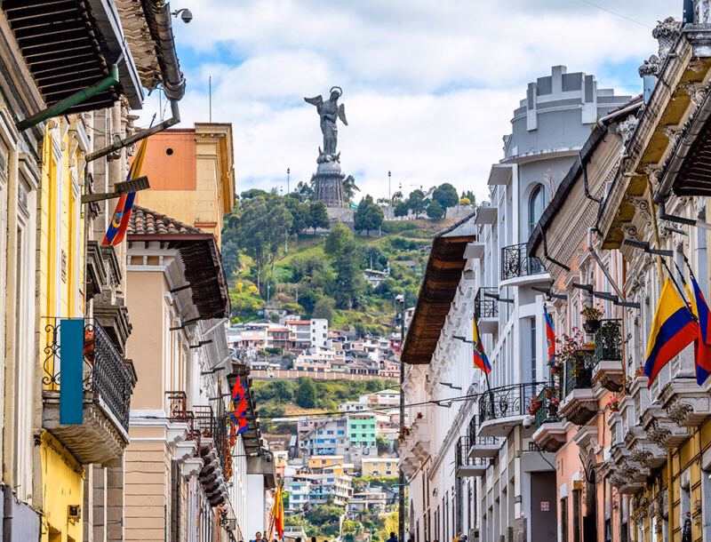 Historic street in Quito with the Panecillo statue in the background on luxury Ecuador trips.