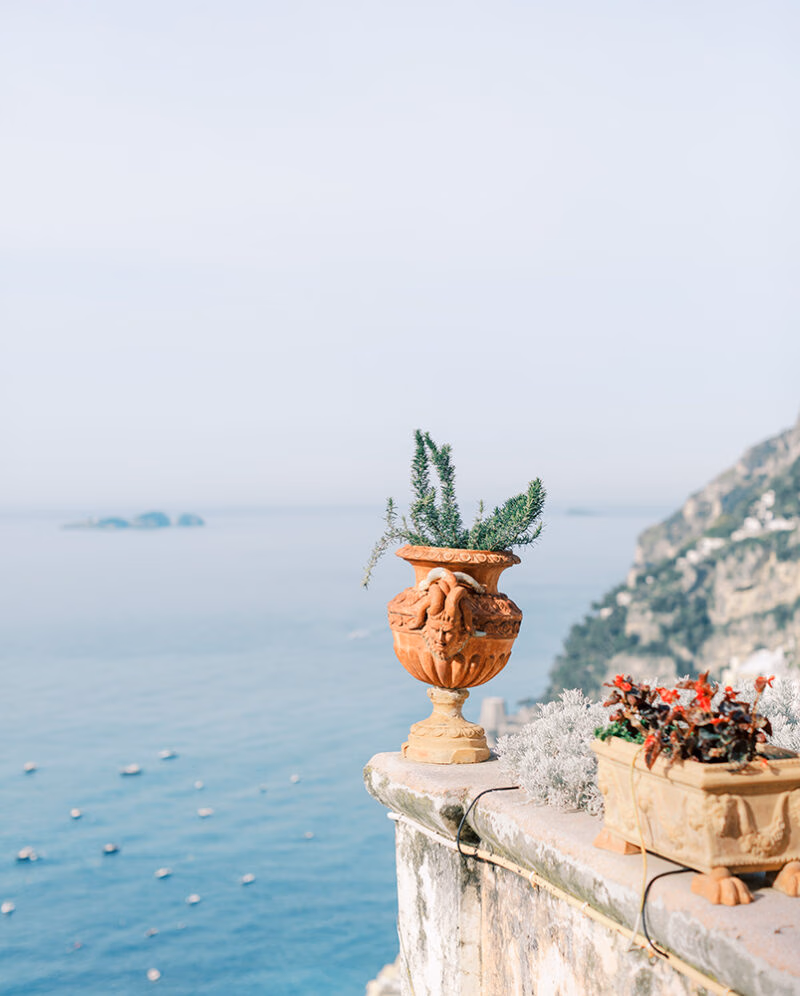Terracotta urn on a balcony overlooking the sea during luxury Amalfi Coast vacations.
