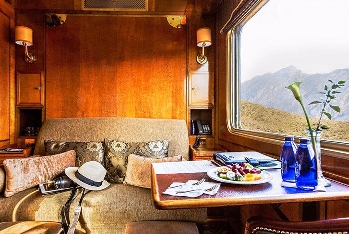 A luxury South Africa rail tours train cabin with a large window overlooking mountains.