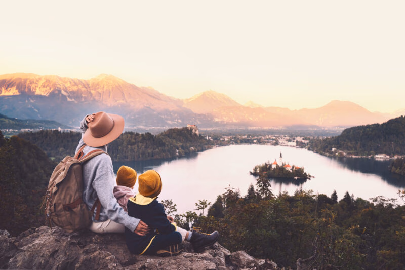 Luxury Grand Tours of Europe - family sitting on hill over lake bled at sunset