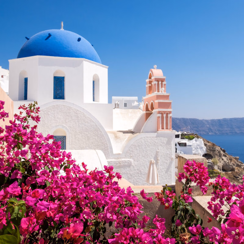 Luxury Grand Tours of Europe - Scenic view of traditional cycladic houses with flowers in foreg