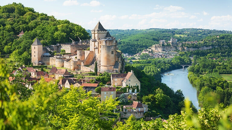 Medieval stone castle on a hilltop overlooking a winding river valley during luxury grand tours.