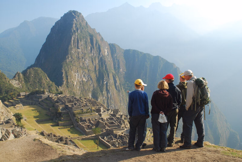 A group of people standing in front of the ancient citadel on Machu Picchu