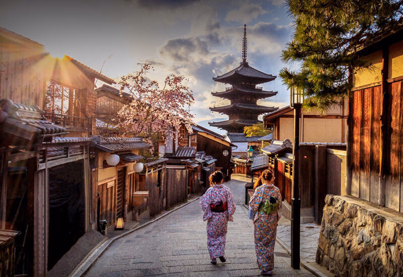 A scenic street view of traditional Japanese architecture and a pagoda during luxury history tours.