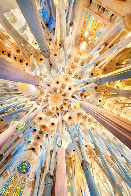 Looking up at the geometric stone ceiling and columns of a cathedral for luxury art tours.
