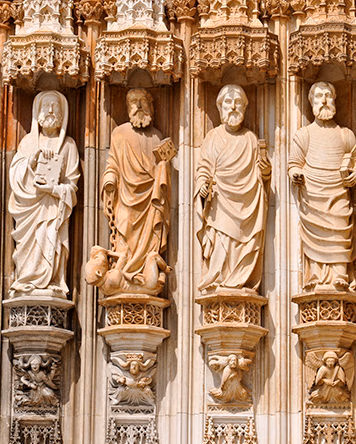 Intricate stone sculptures of saints on the facade of a Gothic cathedral for luxury art tours.