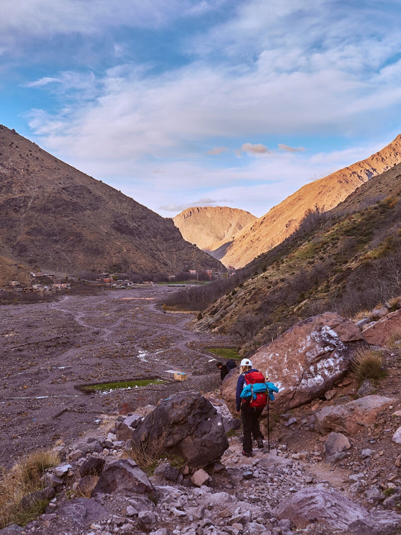 Tourist backpacker girl descending from High Atlas mountains ba