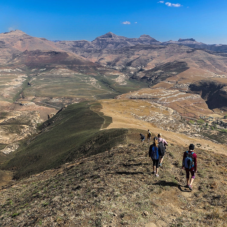 Amazing wide view of a group of hikers walking down the mountain