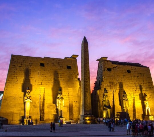 Kuxor temple lit up at night with sunset sky