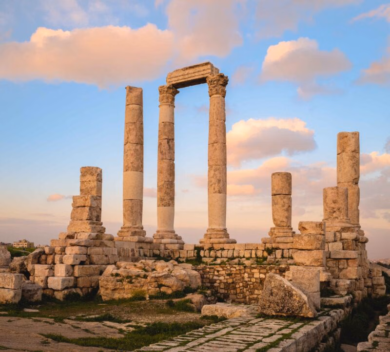The standing columns and ruins of the Roman Temple of Hercules at the Amman Citadel in Jordan at sunset.